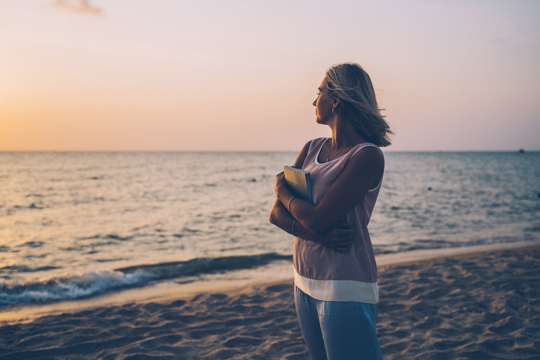 Woman Wearing Sleeveless Top Standing on the Beach during Sunset